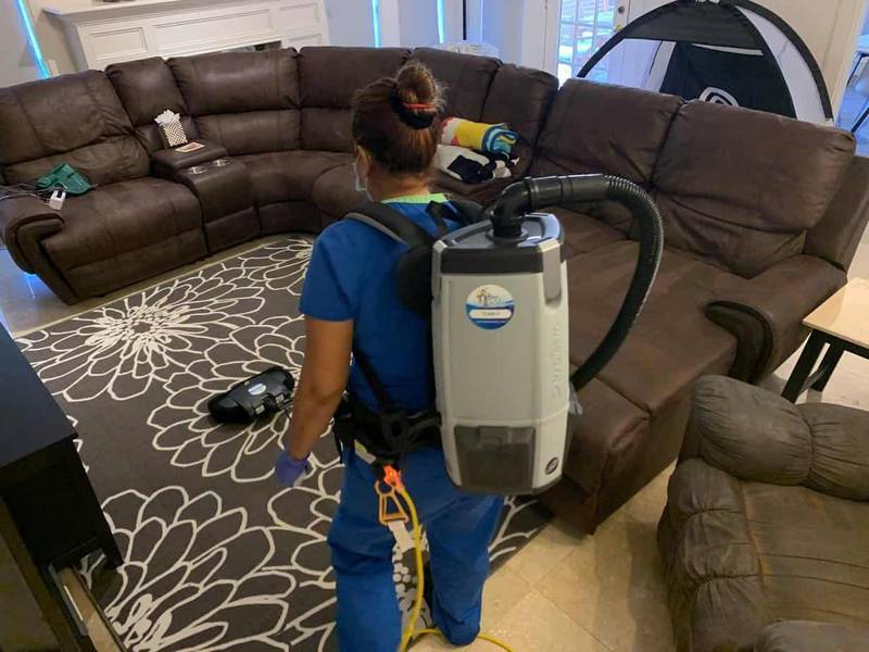 Cleaning tech vacuuming a living room, showcasing Bee Maids’ top-rated house cleaning services in Houston. See why customers leave rave reviews.